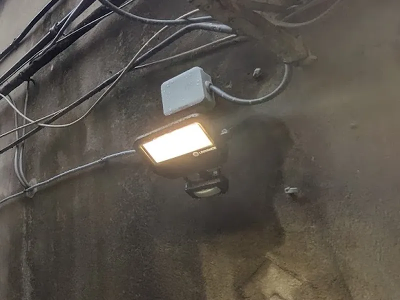 Projecteur LED Ledvance à détecteur posé sur le mur d'une cour