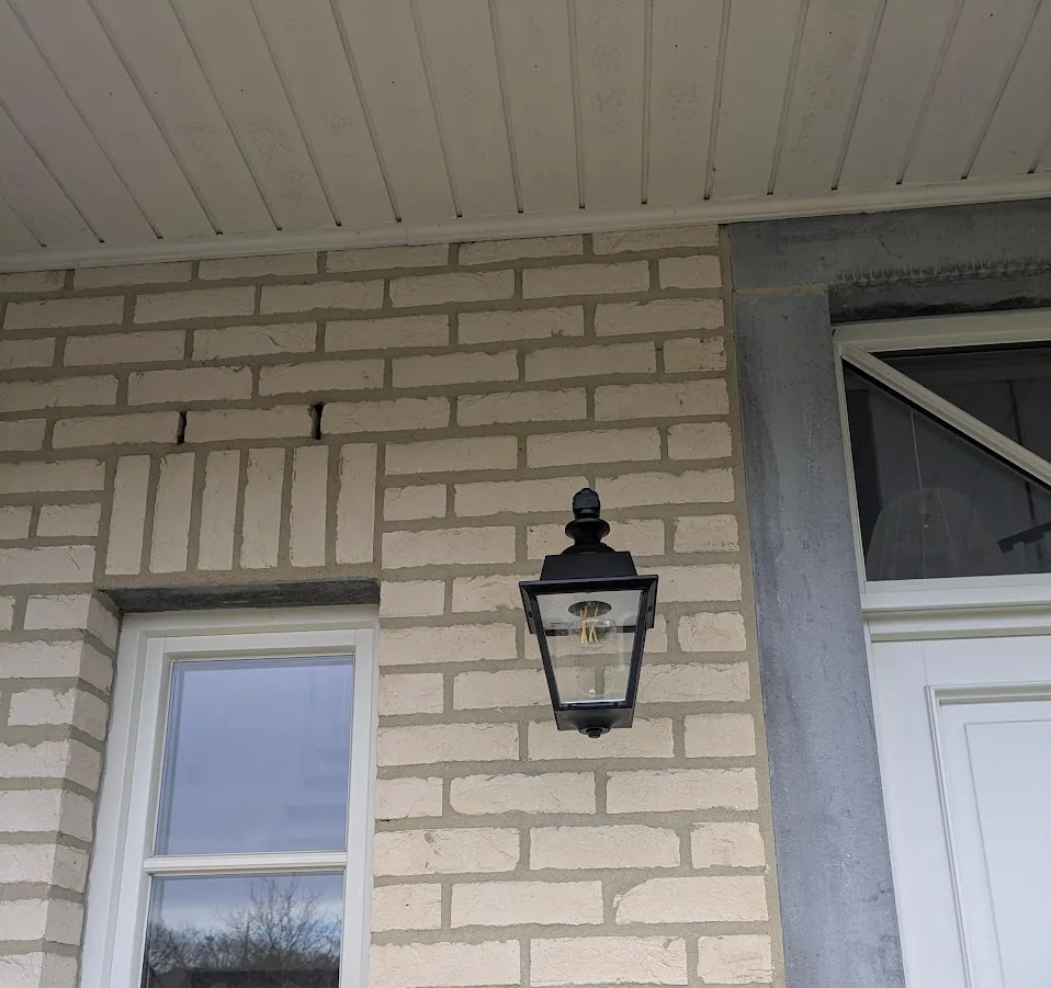 Lanterne extérieure posée sur une façade en brique