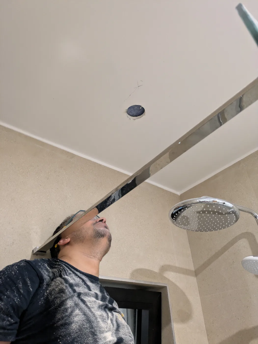 Trou percé au plafond d'une salle de bain pour un nouveau spot